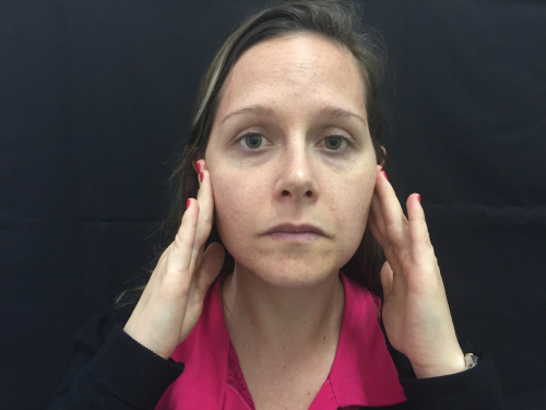 Photo showing a female Patient pointing to the principal area of her facial pain.