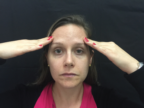 Photo showing a female Patient pointing to the principal area of her headache.